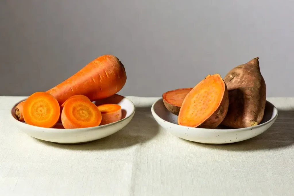 Carrot and sweet potato side by side, photographed for nutritional comparison