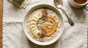 Porridge topped with sliced banana, peanut butter and flaxseed