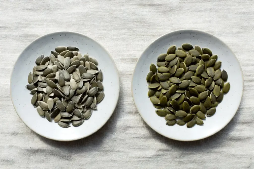 Sunflower seeds and pumpkin seeds side by side, photographed for nutritional comparison