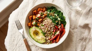Grain bowl with roasted sweet potato, quinoa, spinach, avocado and red pepper